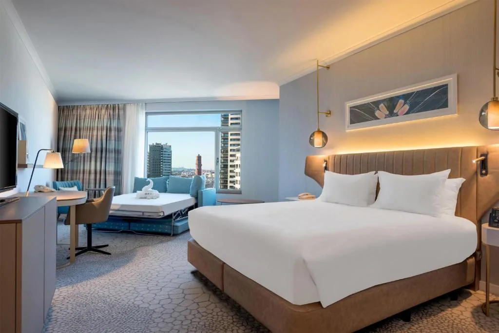 Habitación con cama extragrande y sofá cama — Hilton Diagonal Mar Barcelona