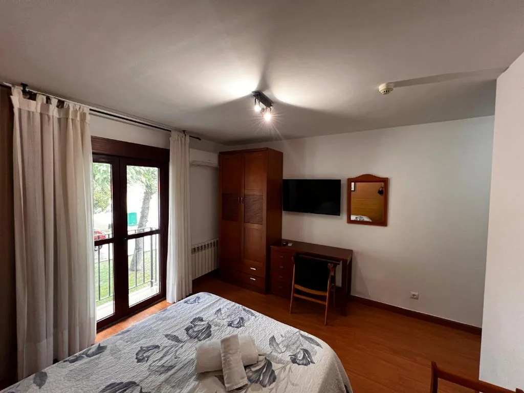 Habitación con cama grande y balcón — Hotel Puente de Piedra