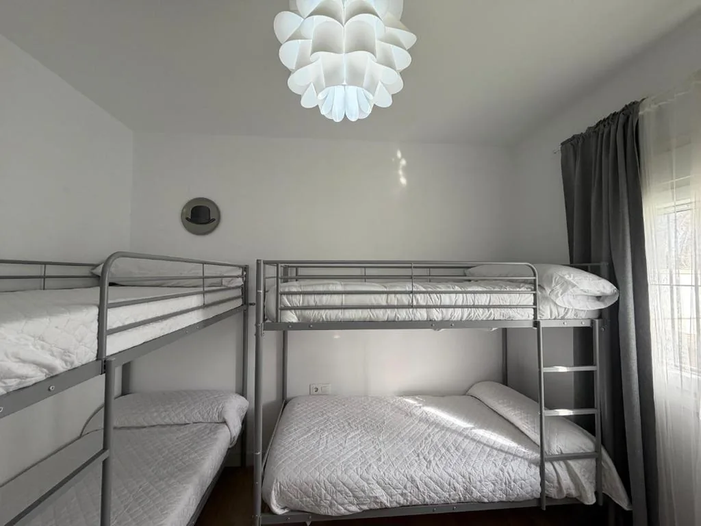Posto letto in dormitorio con 4 letti — La Casita de Community SurfHouse El Palmar