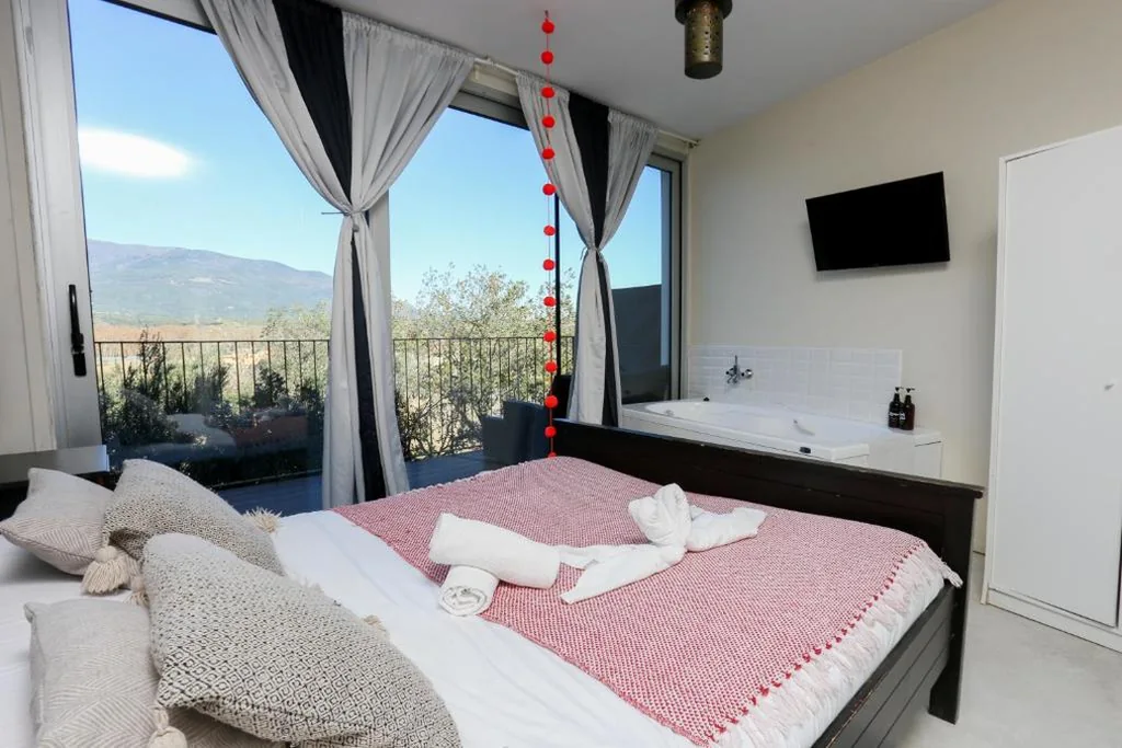 Habitación con cama extragrande y balcón — Les Suites