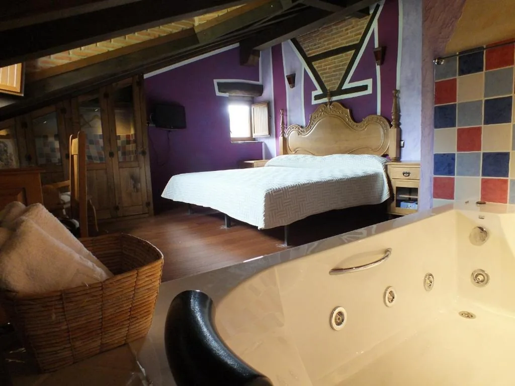 Habitación con cama grande y bañera de hidromasaje — Posada La Braniza